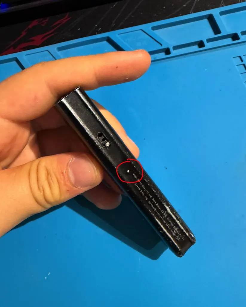 The round aluminium button on the side of the vape